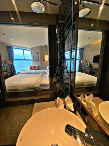 a bathroom with a sink and a bed and a mirror at Apec Mandala Romantic Mui Ne in Ấp Thiẹn Ái