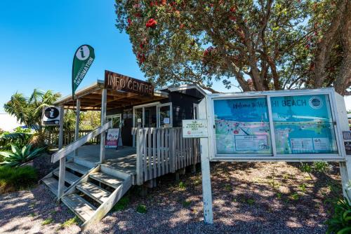 a sign in front of a beach shack at Sun, Sand, Serenity - Waihi Beach Holiday Home in Waihi Beach