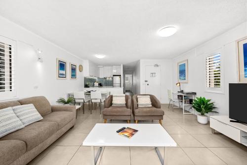 a living room with a couch and a table at Surfers Paradise- meters from the beach! in Gold Coast