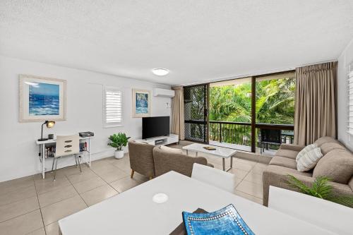 a living room with a couch and a table at Surfers Paradise- meters from the beach! in Gold Coast
