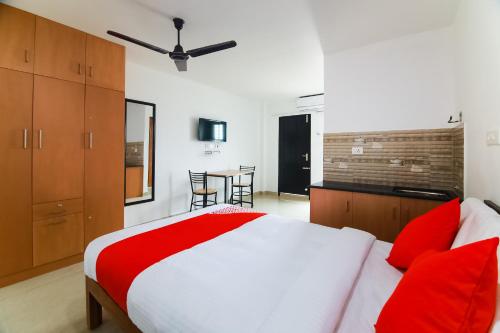 a bedroom with a large bed with red pillows at Modern Rooms in Mundakāyam