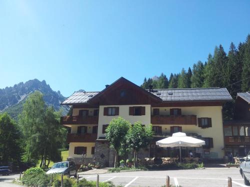 a hotel in the mountains with a parking lot at Albergo Nuoitas in Forni di Sopra