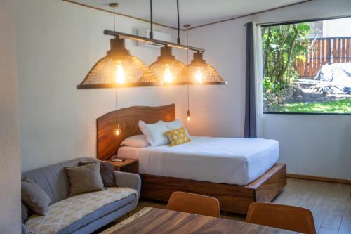 a bedroom with a bed and a couch and a table at Bromelia Studio in Monteverde Costa Rica