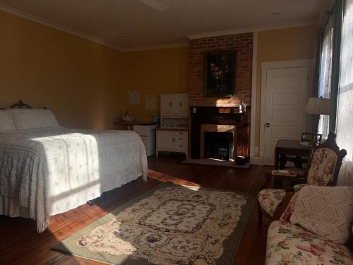 a bedroom with a bed and a living room with a fireplace at Tanglewood Inn in Greenville