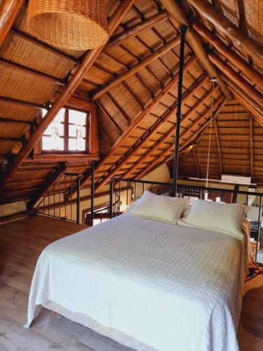 a bedroom with a white bed in a attic at El Charanguito Casa Quinta in Capilla del Señor
