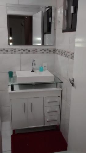 a bathroom with a white sink and a mirror at Casa Rebello - Pousada in Itajaí