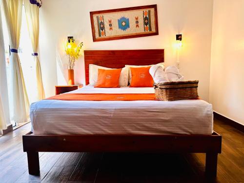 a bedroom with a large bed with orange pillows at Hotel & Suites Cerro Roj0 in Tlatlauquitepec
