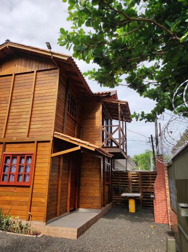 a wooden house with a porch and a balcony at Sobrado Rustico iguacu in Foz do Iguaçu