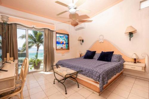 a bedroom with a bed and a desk and a window at Playa Azul Apt with Sea views & Pool in Manzanillo