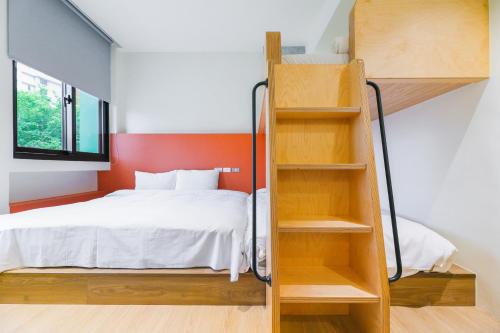 a bedroom with a bunk bed and a ladder at Green Hot Spring Hotel in Jiaoxi