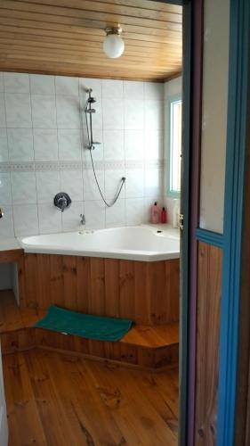 a bathroom with a bath tub with a shower at Cheerful Bush House in Hepburn Springs