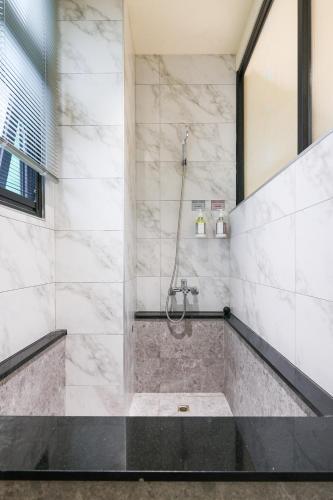 a bathroom with a shower with a tub at Green Hot Spring Hotel in Jiaoxi