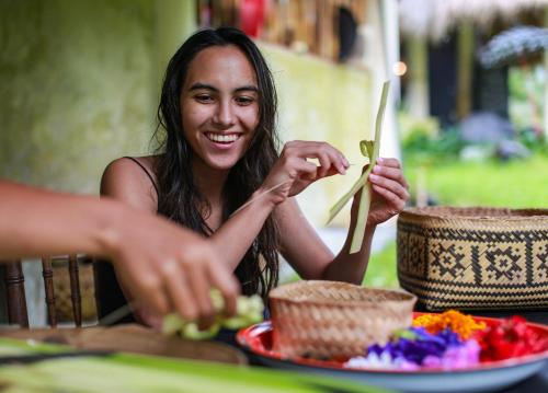 a woman is sitting at a table eating food at Darmada Eco Resort in Sidemen