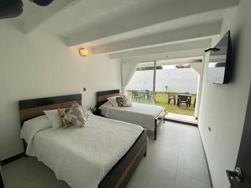 メルガルにあるCasa Quinta Melgarのベッドルーム1室(ベッド2台付)、バルコニー(テーブル付)