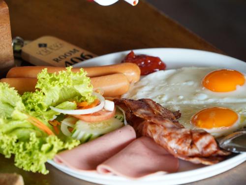 a plate of food with eggs and meat and vegetables at RoomQuest THEVA Resort Koh Samui in Koh Samui 
