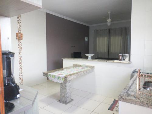 Una sala de estar con una mesa y una cocina. en Casa Recanto em Itanhaém, en Itanhaém