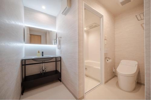 a bathroom with a toilet and a sink and a mirror at RESI STAY Kuon in Kyoto