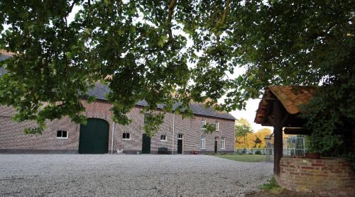 un gran edificio de ladrillo con una puerta verde. en Hoeve Heidonk, en Horn