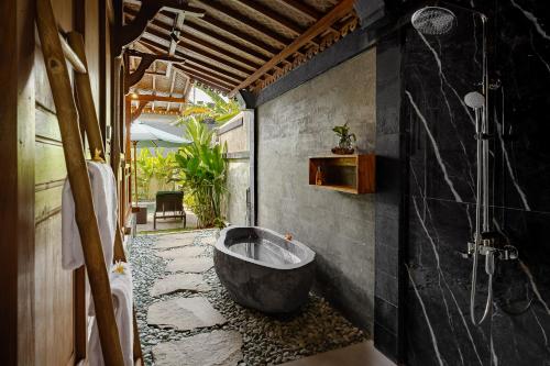 a bathroom with a large bath tub in the corner at Suraya Ubud Villa in Ubud