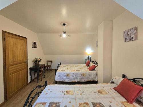 a room with two beds and a table and a door at Maison périgourdine 2 chambres à Salignac-Eyvigues avec cour et jardin, animaux acceptés - FR-1-616-5 in Salignac Eyvigues