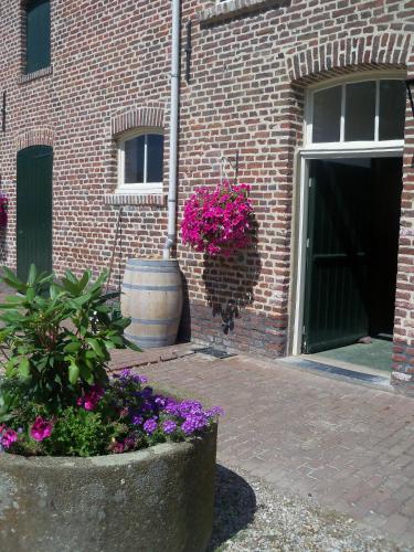 a brick building with flowers in front of a door at Hoeve Heidonk in Horn