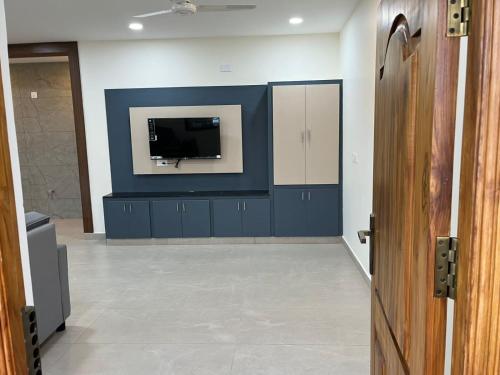 a living room with a tv on a blue wall at Achyuta Homestay in Tirupati