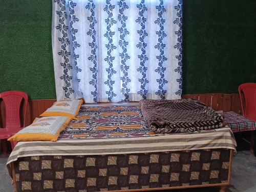 a bed in a room with a curtain at ROOP MOUNTAIN HOMESTAY No Parking in Manāli