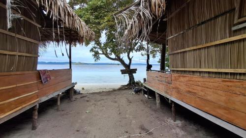 a row of benches sitting on the beach at Raja Ampat Jousuba Homestay in Minyaifuin