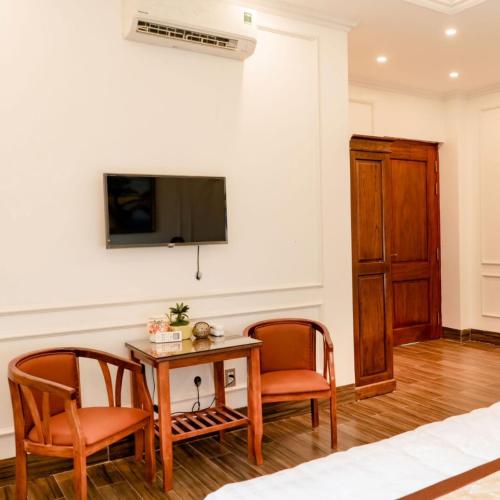 a living room with a table and two chairs and a television at Trang Anh Hotel Bắc Giang in Bắc Giang