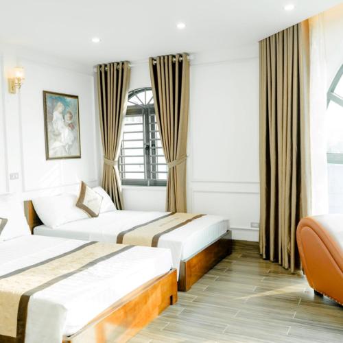 a hotel room with two beds and a couch at Trang Anh Hotel Bắc Giang in Bắc Giang