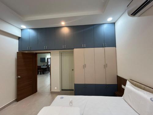 a bedroom with blue and white cabinets and a bed at Achyuta Homestay in Tirupati