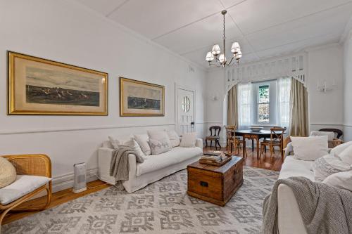 a living room with white furniture and a dining room at Experience The Charm Of Little Plains Homestead in Gunnary