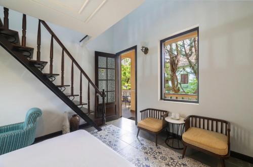 a room with a staircase and two chairs and a table at Villa Trung Nghĩa 16 in Da Lat