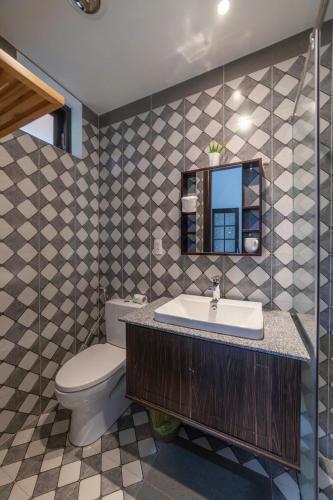 a bathroom with a sink and a toilet and a mirror at Villa Trung Nghĩa 16 in Da Lat