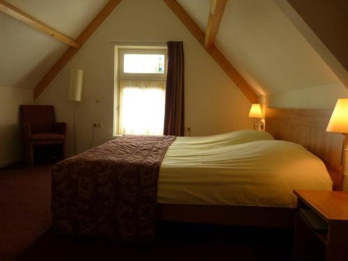 a bedroom with a large bed in a attic at Hotel Brasserie Oud Maren in Maren-Kessel