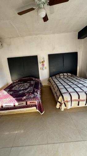 two beds in a bedroom with a ceiling at Hotel Nuevo Vallarta in Guadalajara