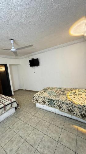 a bedroom with two beds and a flat screen tv at Hotel Nuevo Vallarta in Guadalajara