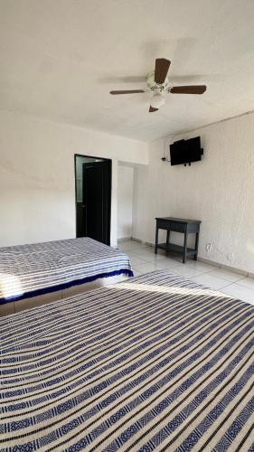 a room with two beds and a ceiling fan at Hotel Nuevo Vallarta in Guadalajara