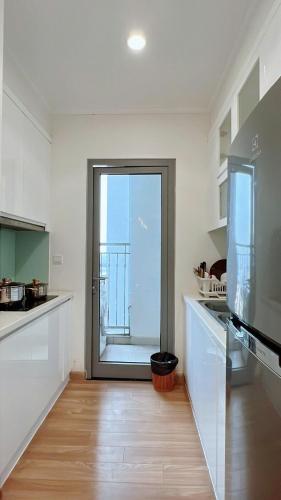 a kitchen with a large glass door to a balcony at KABILUX HOUSE - 1-2-3 Bedrooms in Vinhomes Times City in Hanoi
