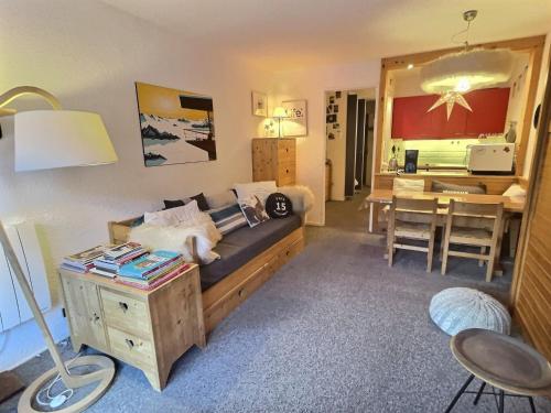 a living room with a bed and a desk with a table sidx sidx at Charmant 2 pièces centre-ville avec balcon | Animaux acceptés | WIFI inclus - FR-1-411-958 in Val dʼIsère