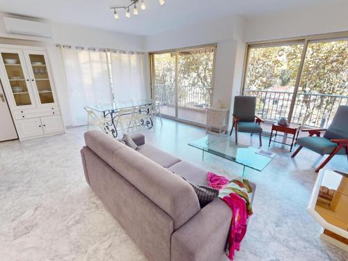 un salon avec un canapé et une table en verre dans l'établissement Spacieux 2P centre Menton avec terrasse, clim et parking privé - FR-1-196-370, à Menton
