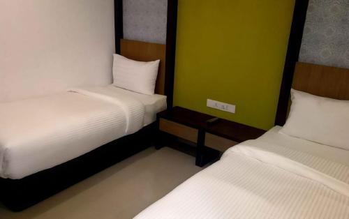 two beds in a small room with twoperate beds at South of The Clouds HOTEL KL Sentral 吉隆坡彩云之南酒店-中央车站店 in Kuala Lumpur
