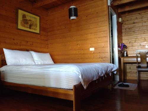 a bedroom with a bed with a wooden wall at Victoria Peak Garden Suburb in Renai