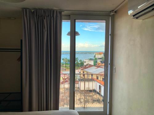 a bedroom with a window with a view of the ocean at Viajero Casco Viejo Hostel in Panama City