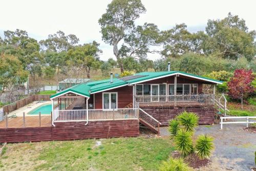 a house with a green roof and a pool at Mansfield Hideaway - Sleeps 10 in Mansfield