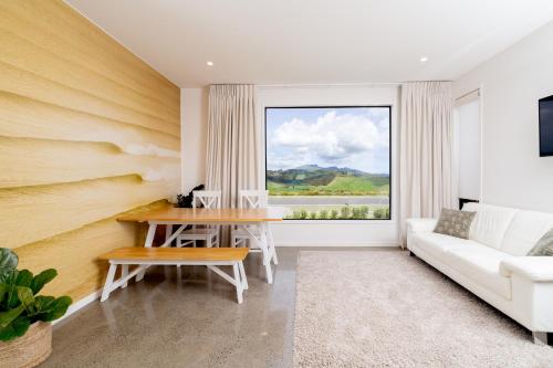 a living room with a table and a couch at Karioi Mountain View in Raglan
