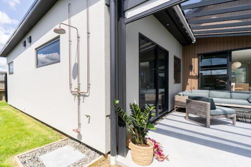 a house extension with a patio and a couch at Karioi Mountain View in Raglan