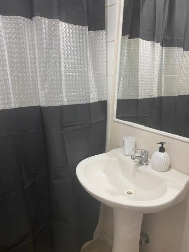 Un baño con lavabo, espejo y ducha. en paseo San Carlos, en Coquimbo