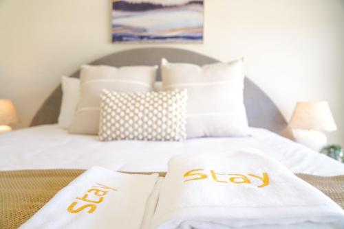 a white bed with two white towels on it at StayAU 5BRM Coastal Retreat for Families Baldivis in Baldivis