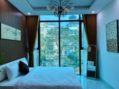 a bedroom with a bed and a large window at The Grand Diamond C Tuong Mai in Hanoi